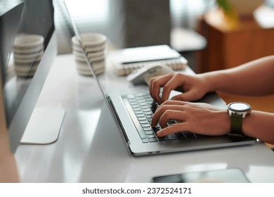 Hands of software developer coding on laptop at home