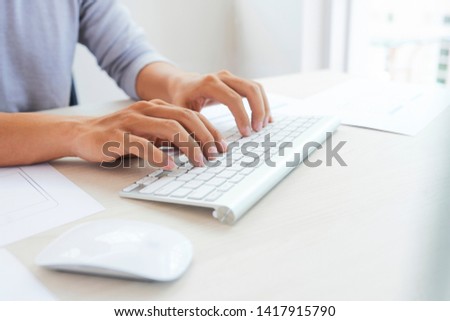 Hands of software developer working on computer at his office table