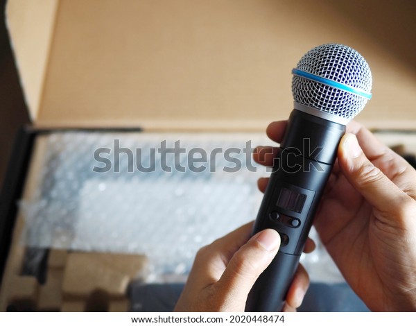 Hands of sound technician holding and assembling\
wireless microphone cartridge or capsule, equipment set up for live\
streaming or live performance. Enjoy Music and Entertainment.\
(selective focus)