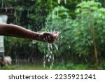 hands with splashes of falling rain