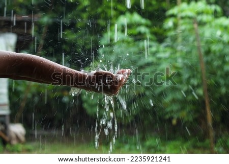 hands with splashes of falling rain