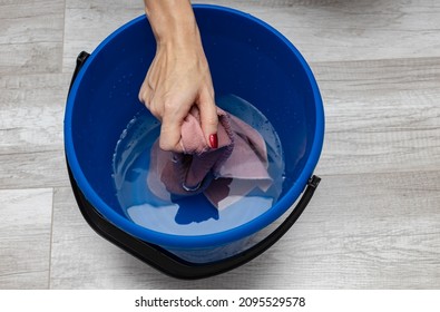 hands squeeze a rag from water in a bucket. High quality photo