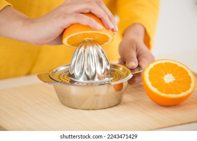 hands squeezing the juice of an orange