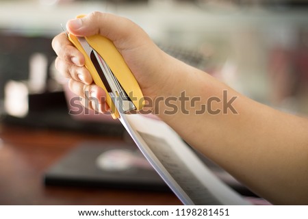 Hands and Stapler. stapling machine