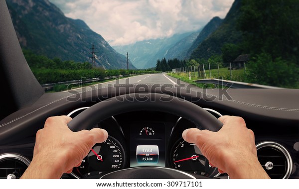 Hands steering\
wheel. Highway car\
driving.