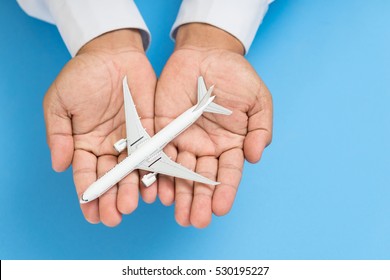 Hands support airplane model, travel insurance concept.
