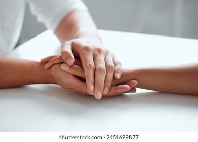 Hands, support and hope for console or care on table, comfort empathy for bad news or illness. Closeup, people and unity in crisis by prayer, trust or bond for person suffering with diagnosis - Powered by Shutterstock