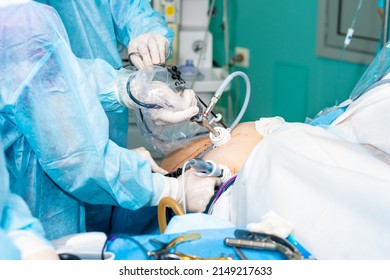 Hands of surgeons operate on a patient. Selective focus. Laparoscopic manipulators in the hands of doctors. Surgical treatment of proctological diseases.