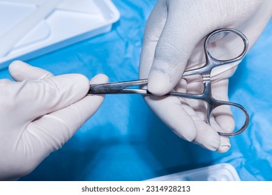 Hands with surgical tools and medical scissor - Shutterstock ID 2314928213