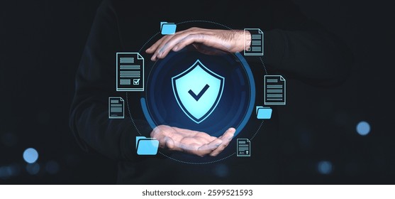 Hands surrounding a glowing shield icon with checkmark, symbolizing cybersecurity and data protection. Floating digital documents and folders on dark
