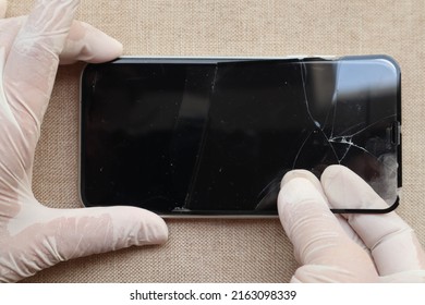 Hands taking out broken glass shield or film screen cover of smartphone -  safety and protection concept  - Shutterstock ID 2163098339