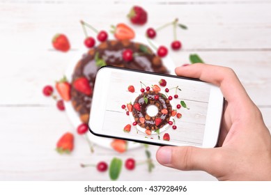 Hands taking photo homemade berry  cake with chocolate with smartphone. - Powered by Shutterstock