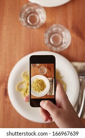 Hands Taking Photo Of Italian Pasta Lunch With Smartphone