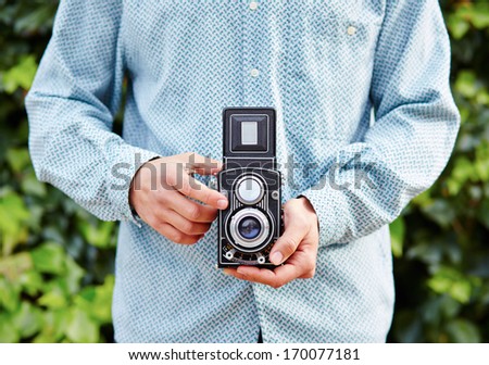 Hands taking photo with TLR camera close-up