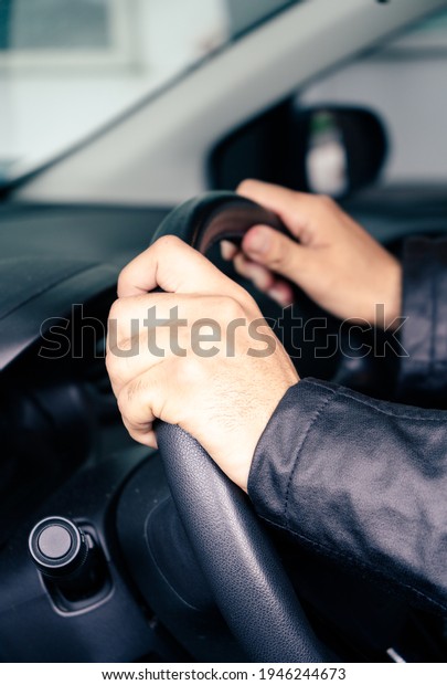 Hands taking the wheel of a car. Transportation\
and success concept.