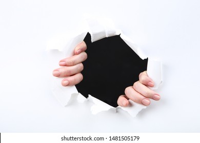 Hands Tearing Hole In White Paper