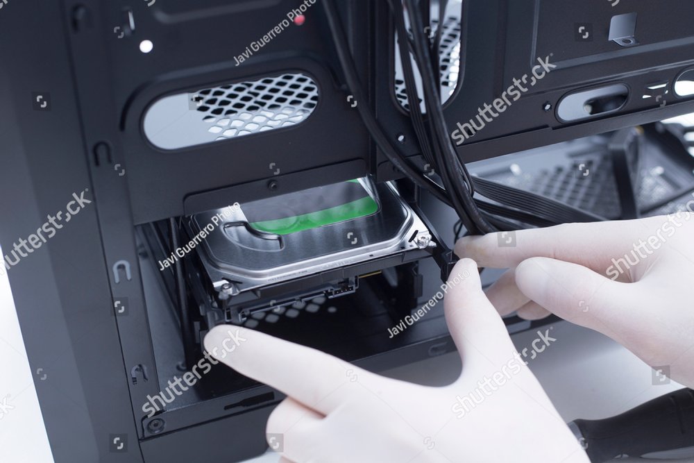 Hands of a technician assembling computer hardware parts. Hard drive ...