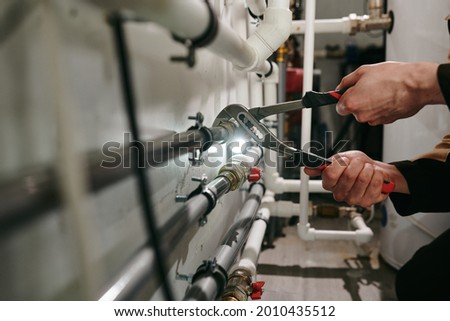 Hands of technician or plumber repairing broken pipes in toilet