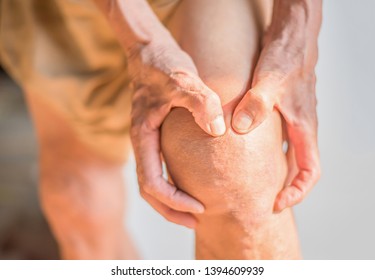 Hands that are holding knees that have problems with the deterioration of the bones of the elderly