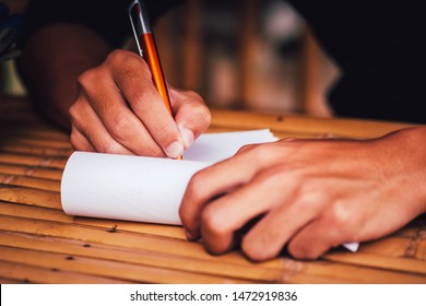 Hands that are taking notes on the book