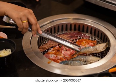 Hands Tossing Food At The Grill In A Shabu-shabu Restaurant