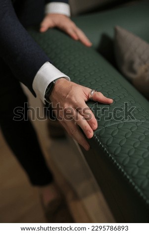 Hands touching sofa holding and feeling the softness and quality of furniture smart man professional designer