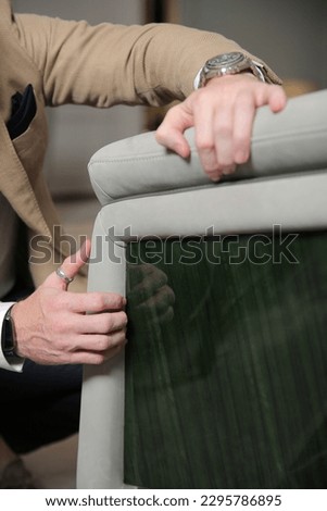 Hands touching sofa holding and feeling the softness and quality of furniture smart man professional designer