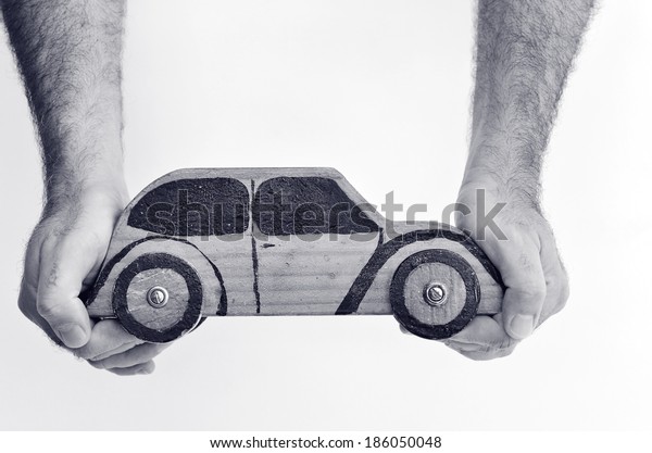 Hands and toy car isolated on white background -\
copy space.Concept photo of car business, car Insurance, auto\
dealership,car rental ,safe driving ,buying, renting, fuel, service\
and repair costs (BW)