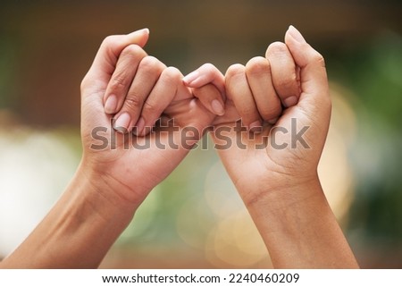 Hands, trust and promise of women friends for pledge of intimate secret, confession and bond. Care, support and pinky promise for confidential moment together with nature bokeh effect zoom.