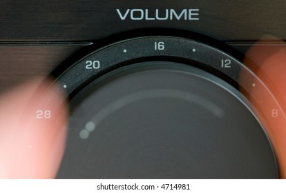 Hands Turning Up The Volume On A Stereo