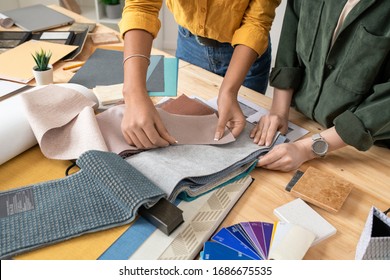 Hands of two female designers of interior standing by desk and choosing fabric samples for one of new orders while working in studio - Powered by Shutterstock