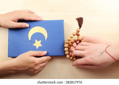 Hands Of Two Friends With Different Religions Symbols