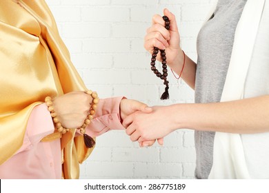 Hands Of Two Friends With Different Religions Symbols