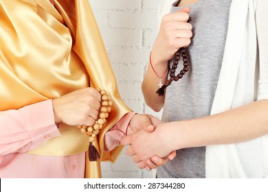 Hands Of Two Friends With Different Religions Symbols