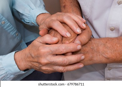 Hands of two loving senior people on a dark background. Coronavirus CoVid-19, illness and senior people concept