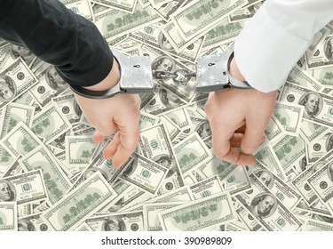 Hands Of Two Men Fixed In Handcuffs. Close Up. Dollars At Background. Concept Of Accessory Of Crime.