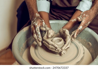 Hands of two people making a new pottery product together - Powered by Shutterstock