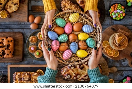 Hands of two women with Easter buns and Easter eggs. Paskalya coregi