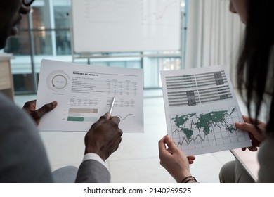 Hands of two young intercultural delegates or econmists discussing documents with graphs and charts while sitting at conference - Shutterstock ID 2140269525