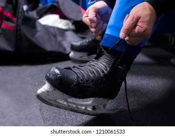 hands tying shoelaces of ice hockey skates in locker room - Powered by Shutterstock