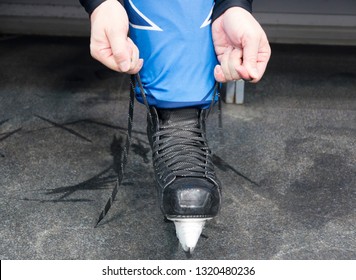 Hands Tying Shoelaces Of Ice Hockey Skates