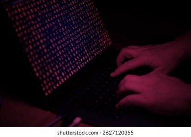 Hands typing on the computer keyboard, red light, cyber crime. Technpology, cyber cattack, system hacked, virus, binary code.