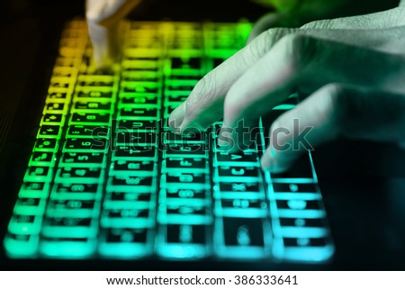 hands typing on keyboard in green light with motion blur,Concept for cybercrime hack cloud security
