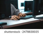 Hands typing on a keyboard and using a mouse at a busy training center, focusing on repairing hardware and troubleshooting it issues