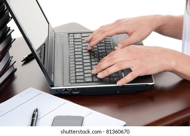 Hands typing on the laptop computer keyboard in an office at a workplace isolated on a white background