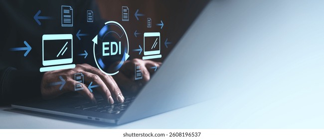 Hands typing on a laptop with digital EDI icons, arrows, and document symbols overlay. Technology and automation concept on a dark background