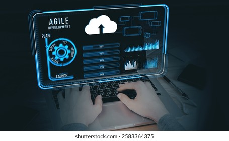 Hands typing on a laptop with a holographic agile development interface, featuring cloud, charts, and workflow diagrams on dark background