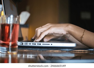 Hands Typing on Laptop with Refreshing Drink. work from home - Powered by Shutterstock