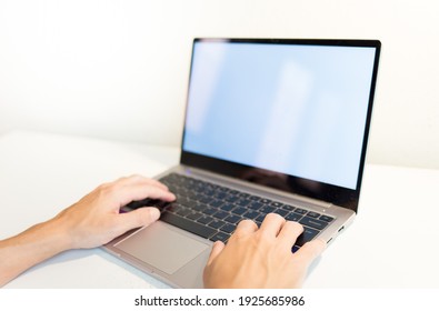 Hands Typing On Laptop On A White Table.