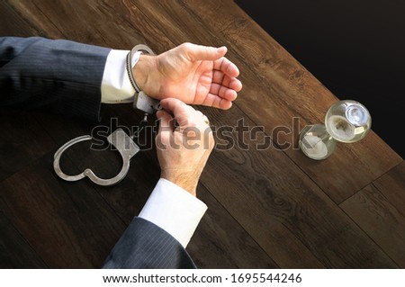 Hands unfasten the handcuffs. Open handcuffs on the male hands of the arrested person. Acquittal of an innocent defendant , a businessman in a black suit. Termination of criminal prosecution.         